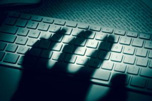 Shadow hand over computer keyboard